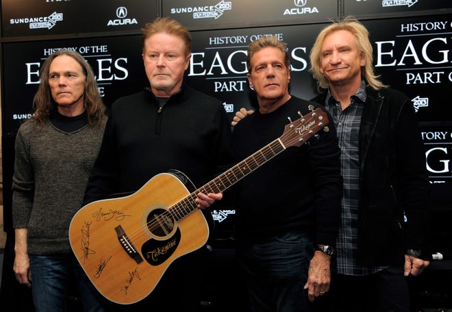 Members of The Eagles, from left, Timothy B. Schmit, Don Henley, Glenn Frey and Joe Walsh pose with an autographed guitar after a news conference at the Sundance Film Festival.