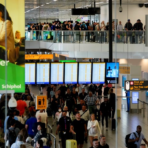 Travelers wait in long lines to check in and board