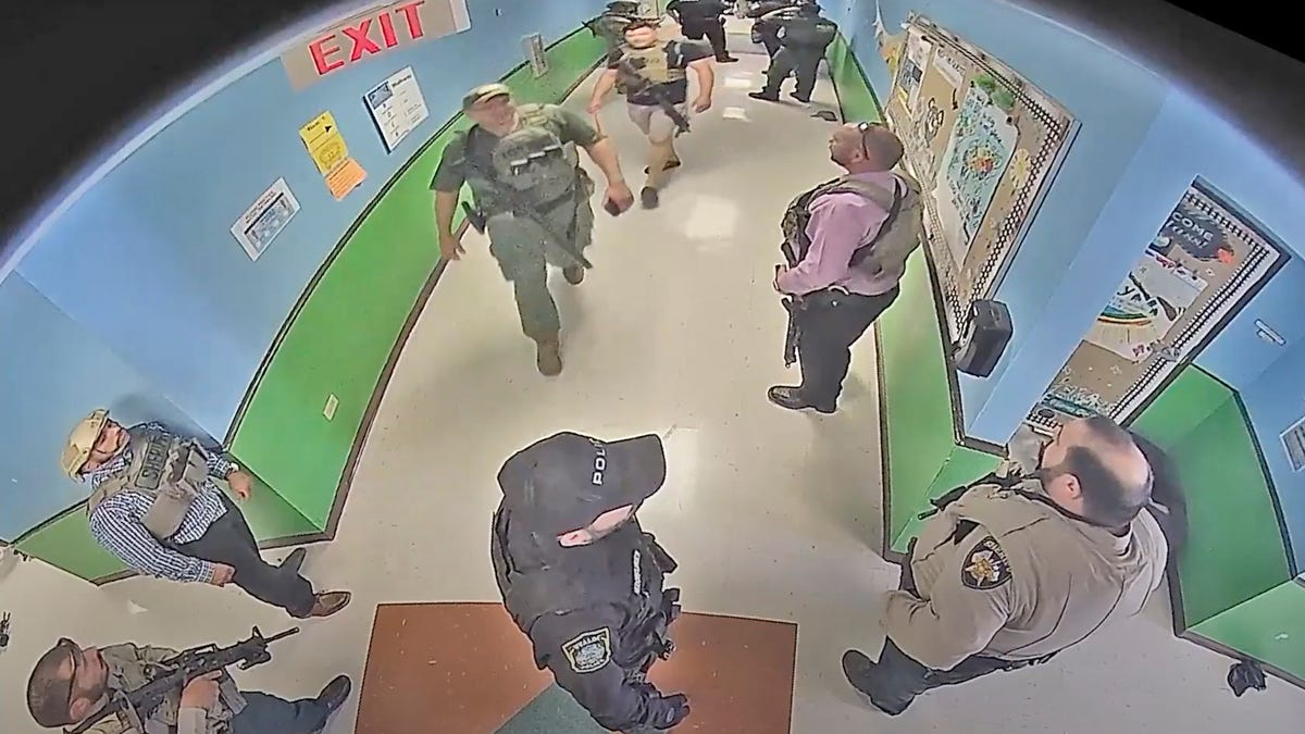 In this photo from surveillance video provided by the Uvalde Consolidated Independent School District via the Austin American-Statesman, authorities stage in a hallway as they respond to the shooting at Robb Elementary School in Uvalde, Texas, Tuesday, May 24, 2022.