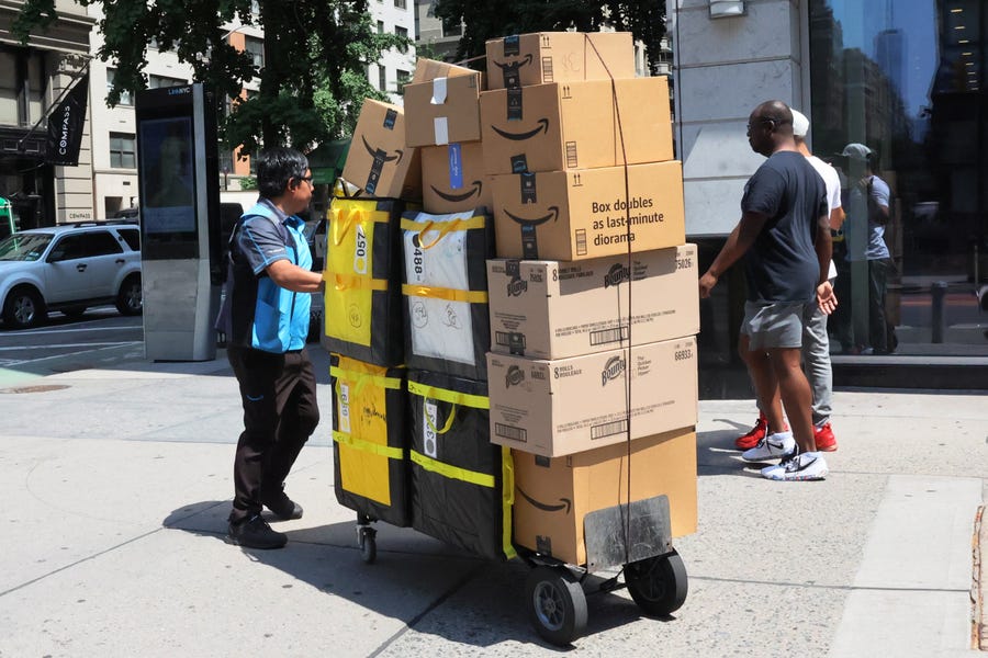 An Amazon workers pull a cart of packages for delivery on E 14th Street on July 12, 2022 in New York City. Amazon is holding Amazon Prime Day in more than 20 countries, offering exclusive discounts on thousands of products, from July 12-13.