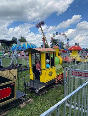 Harper Rice peeks out of the engine as she rides the train at the Mercer County Fair.