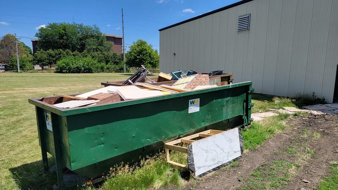 A dumpster outside of Galesburg High School filled with furniture from the high school theater department's inventory.