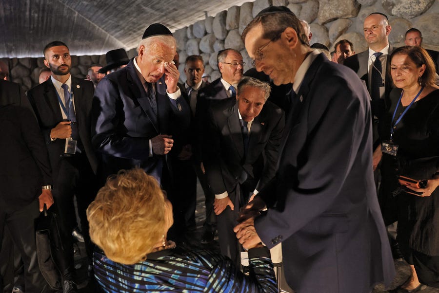 US President Joe Biden standing to the left of US Secretary of State Antony Blinken reacts, as Israel's President Isaac Herzog speaks with Holocaust survivor Rena Quint, at the Hall of Remembrance of the Yad Vashem Holocaust Memorial museum in Jerusalem, on July 13, 2022.