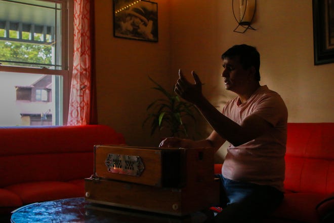 Dil Khadka, whose music has earned him a dedicated following among the Nepali-speaking community, plays the harmonium in his living room in Reynoldsburg.