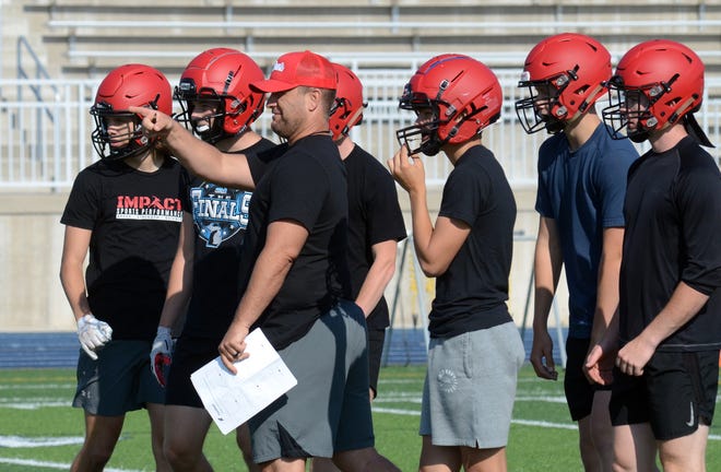 New East Jordan football coach Adam Grybauskas goes over a few things with players at the Petoskey 7-on-7 event earlier this week.