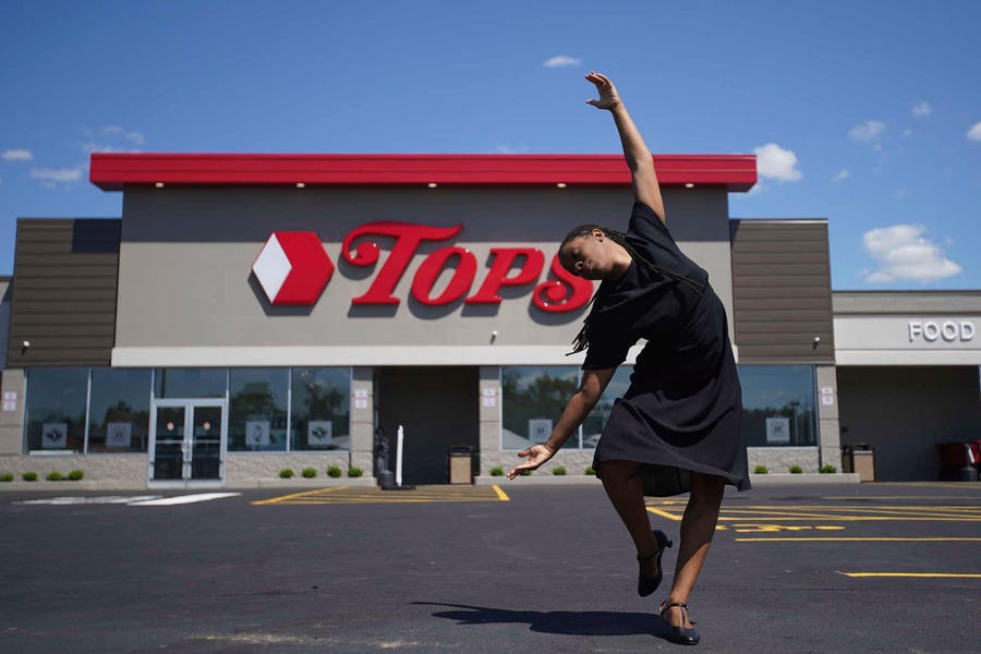Jacquie Cherry of the African American Cultural Center performs an interpretive dance as Tops Friendly Markets holds a ceremony to honor the victims on the two-month anniversary of the attack by a racist gunman at a memorial outside the store in Buffalo, New York.