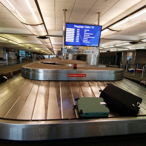 Two pieces of luggage are carried on a carousel in
