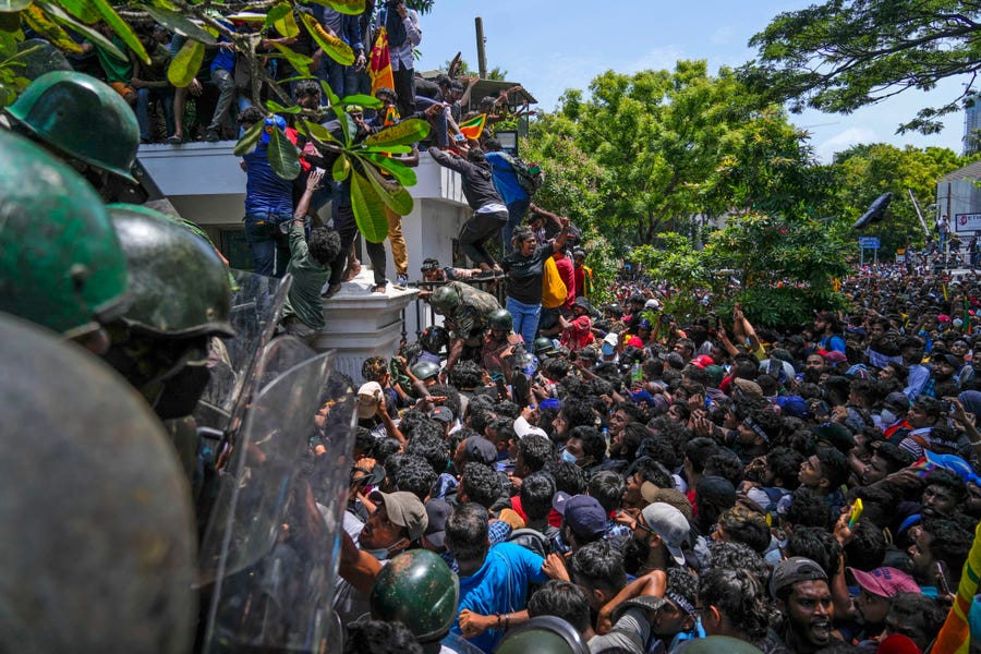 Protesters storm the Sri Lankan Prime Minister Ranil Wickremesinghe's office, demanding he resign after president Gotabaya Rajapaksa fled the country amid economic crisis in Colombo, Sri Lanka, Wednesday, July 13, 2022.