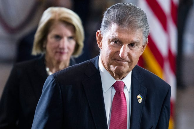 Sen. Joe Manchin, D-W.Va., and Sen. Shelley Moore Capito, R-W.Va., pay their respects as the flag-draped casket bearing the remains of Hershel W. "Woody" Williams, lies in honor in the U.S. Capitol, Thursday, July 14, 2022 in Washington. Manchin has told Senate Majority Leader Chuck Schumer that he will oppose a economic measure if it includes climate or energy provisions or boosts taxes on the rich or corporations. (Tom Williams/Pool photo via AP) ORG XMIT: WX122