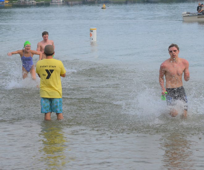 Harper Creek senior Justin LaFleur, right, gets to his feet first to start running to the finish line ahead of second-place Lillian Mahar to win the 95th annual Goguac Lake Swim on Saturday.