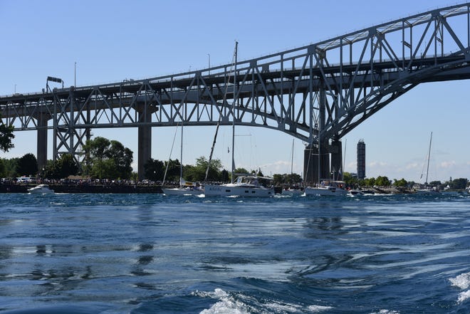 Sailboats pass underneath the Blue Water Bridge prior to the start of the Bayview Mackinaw Race on Lake Huron in Port Huron on Saturday, July 16, 2022.