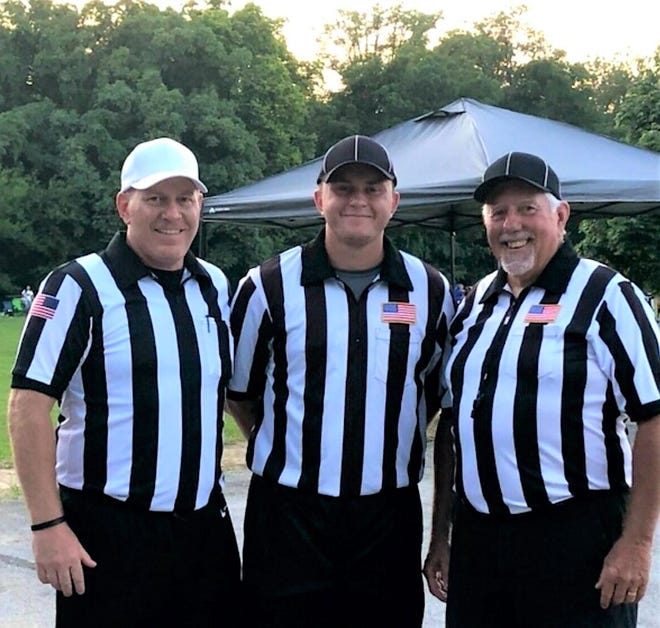 (Left to right) Jeff, Cameron and Randy Gwin pose after refereeing a game together on August 8, 2020.