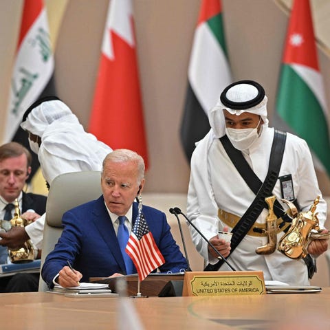President Joe Biden takes notes while an usher ser