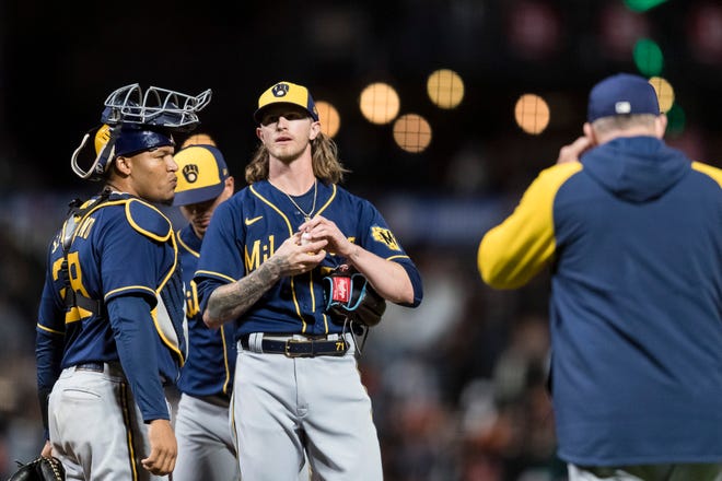 Brewers pitching coach Chris Hook heads to the mound to have a talk with closer Josh Hader during the ninth inning Friday night in San Francisco.