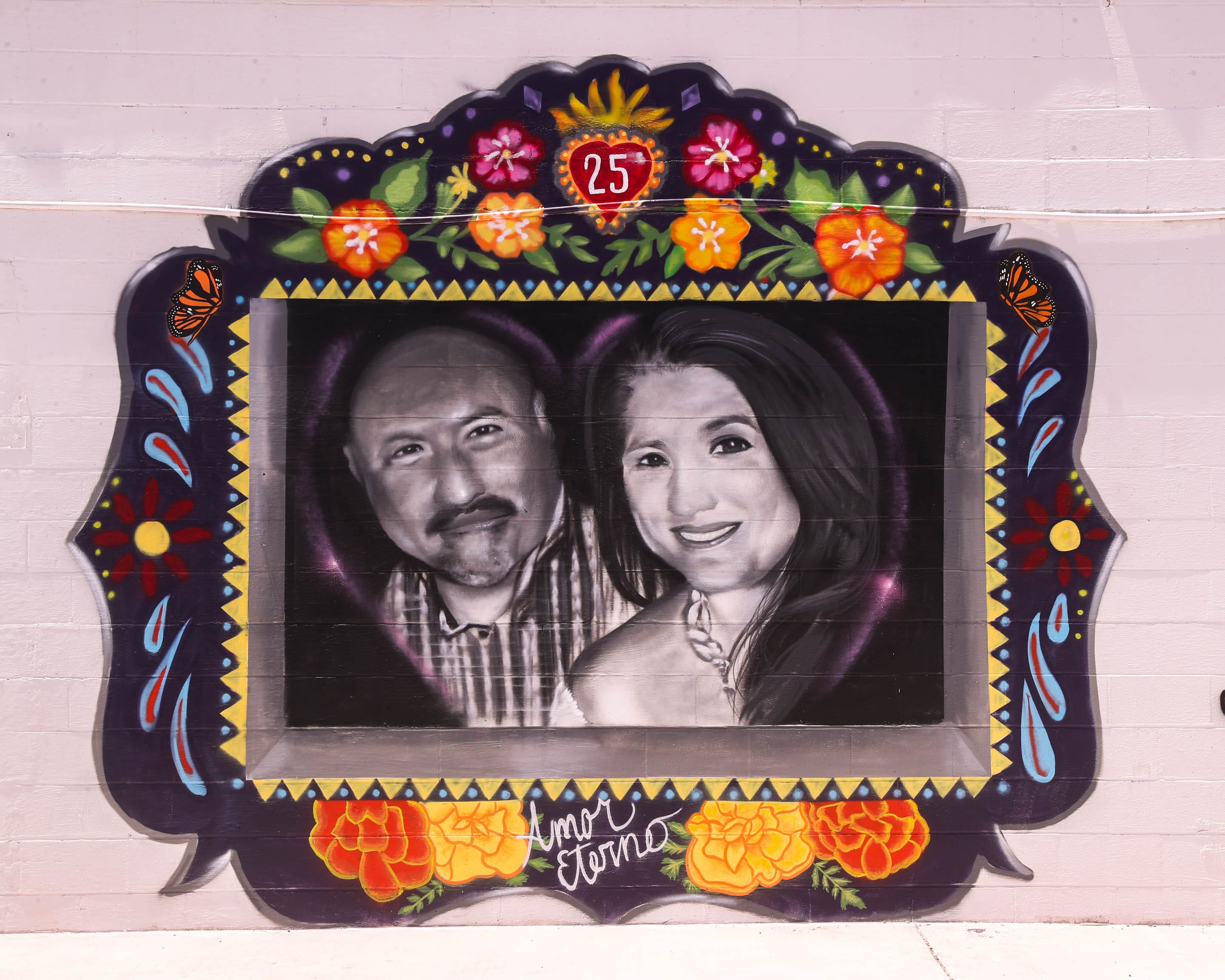 Robb Elementary teacher Irma Garcia is painted with her husband, Joe Garcia, in a nicho box surrounded by marigolds at the Quality Print Solutions building, 123 N. High St., near downtown Uvalde.