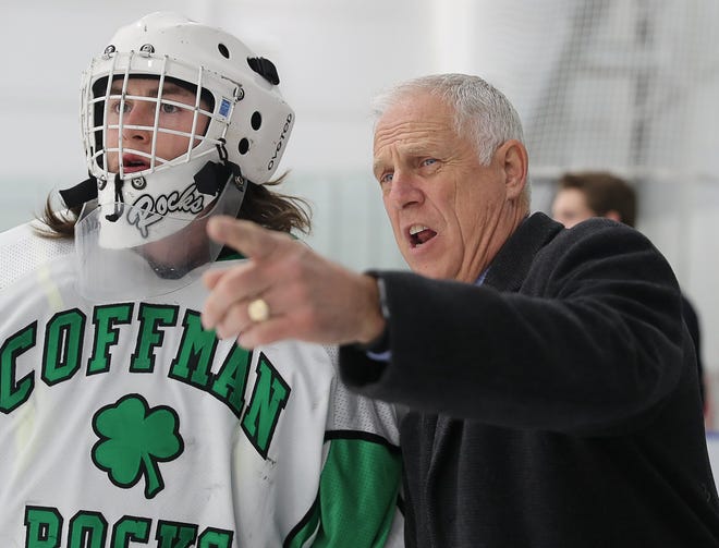 Coffman hockey coach Jeff Kerr talks with goalie Will Pace before a game last season. Kerr has stepped down as coach after three seasons.