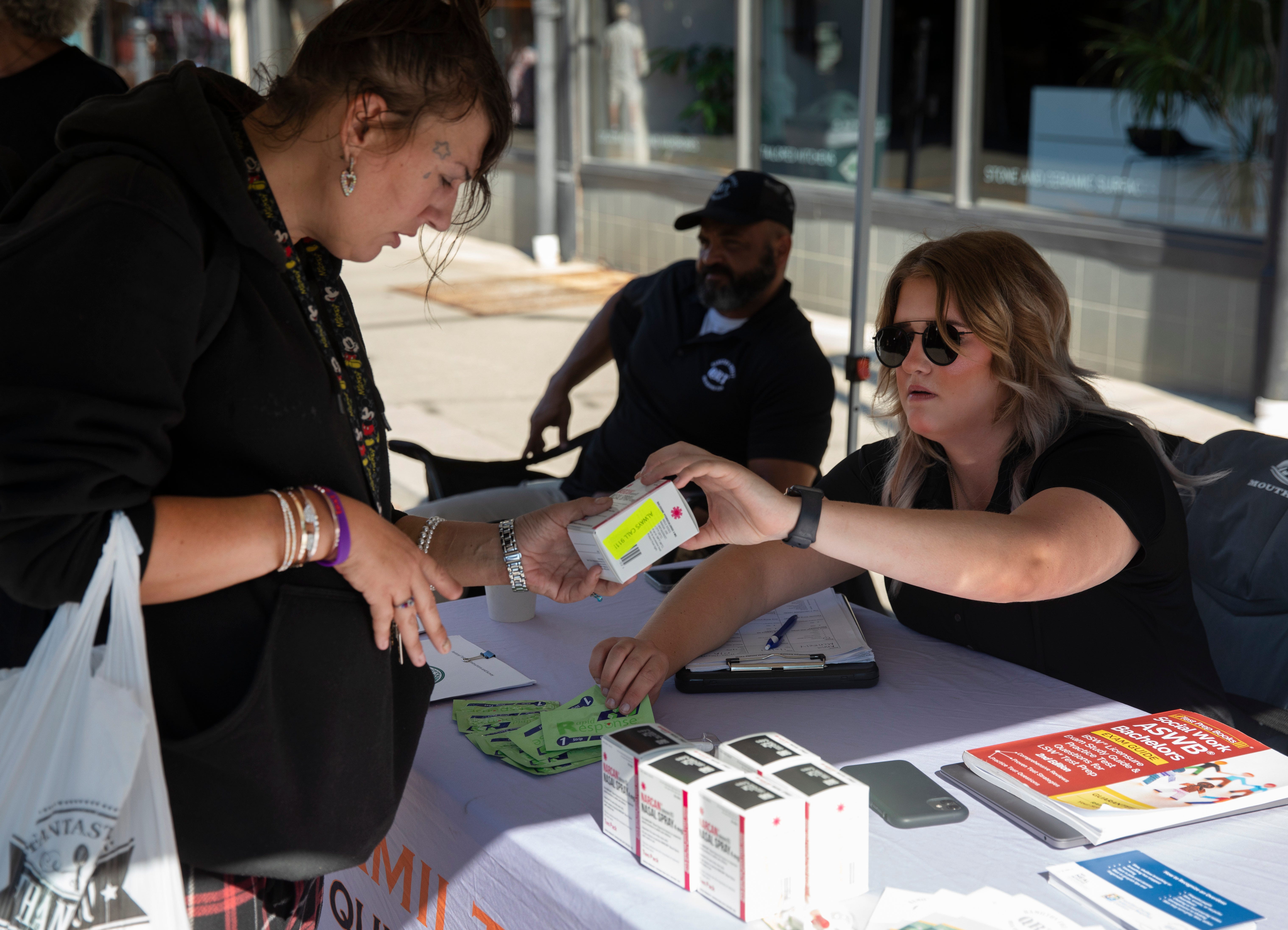 Alyssa Boiman, a social worker with the Quick Response team, talks with a woman from Bond Hill at Findlay Market, Friday, July 15, 2022. The woman was given Narcan and fentanyl test strips.