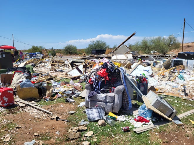 A chair stands amid debris with clothes and belongings family members recovered from Suzette García's home after it was destroyed during a storm on July 17, 2022.