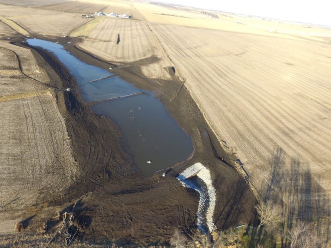 Aerial view of a water outlet near a farm.