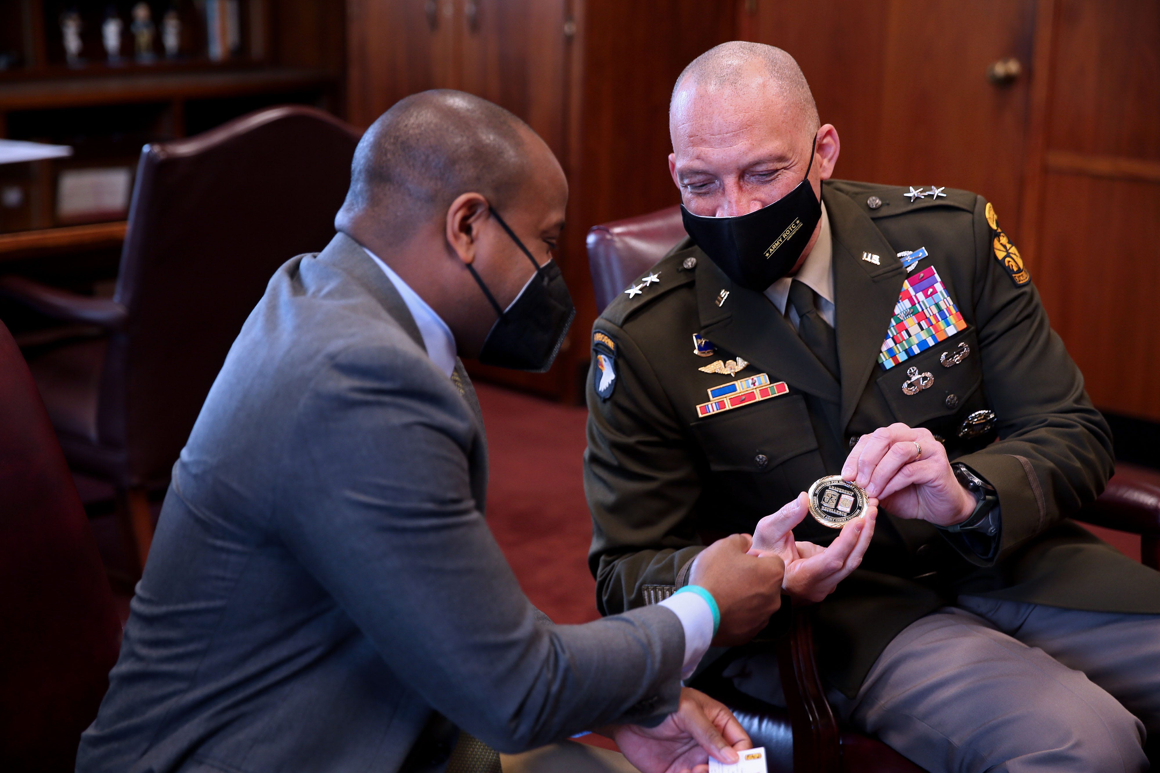 Mayor Cavalier Johnson, left, is presented with the CG commanders challenge coin from United States Army Major General Johnny K. Davis May 23 at Milwaukee at City Hall. The coin was given to Johnson as an appreciation for partnering with the JROTC programs in the city.
