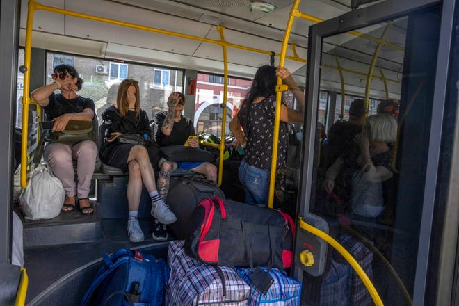 People wait on an evacuation bus in Kramatorsk, eastern Ukraine, Tuesday, July 19, 2022. Donetsk Pavlo Kyrylenko said four Russian strikes had been carried out on the city of Kramatorsk, and he urged civilians to evacuate.