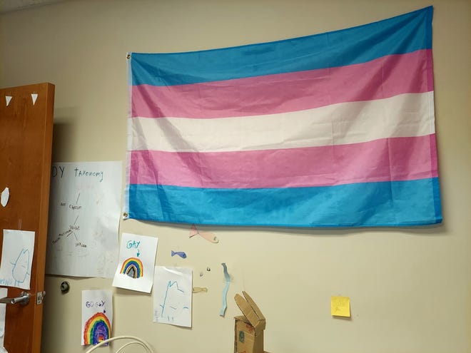 A wall with a transgender pride flag and student artwork at Our Resilient Community LGBTQ+ homeschool and community center.