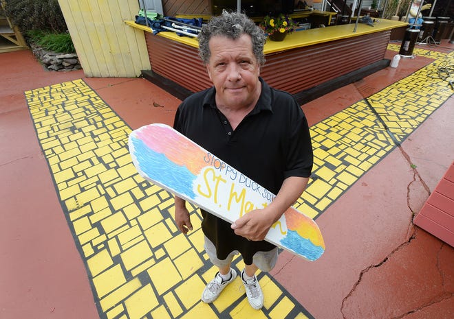 Sloppy Duck Saloon owner Dave Litz Jr. holds a sign while working on an outdoor bar, on May 29, 2020, on Erie's bayfront as he prepared for the bar's opening for the season on June 5, 2022. Restaurant owners are making changes for outdoor seating due to the COVID-19 coronavirus pandemic.