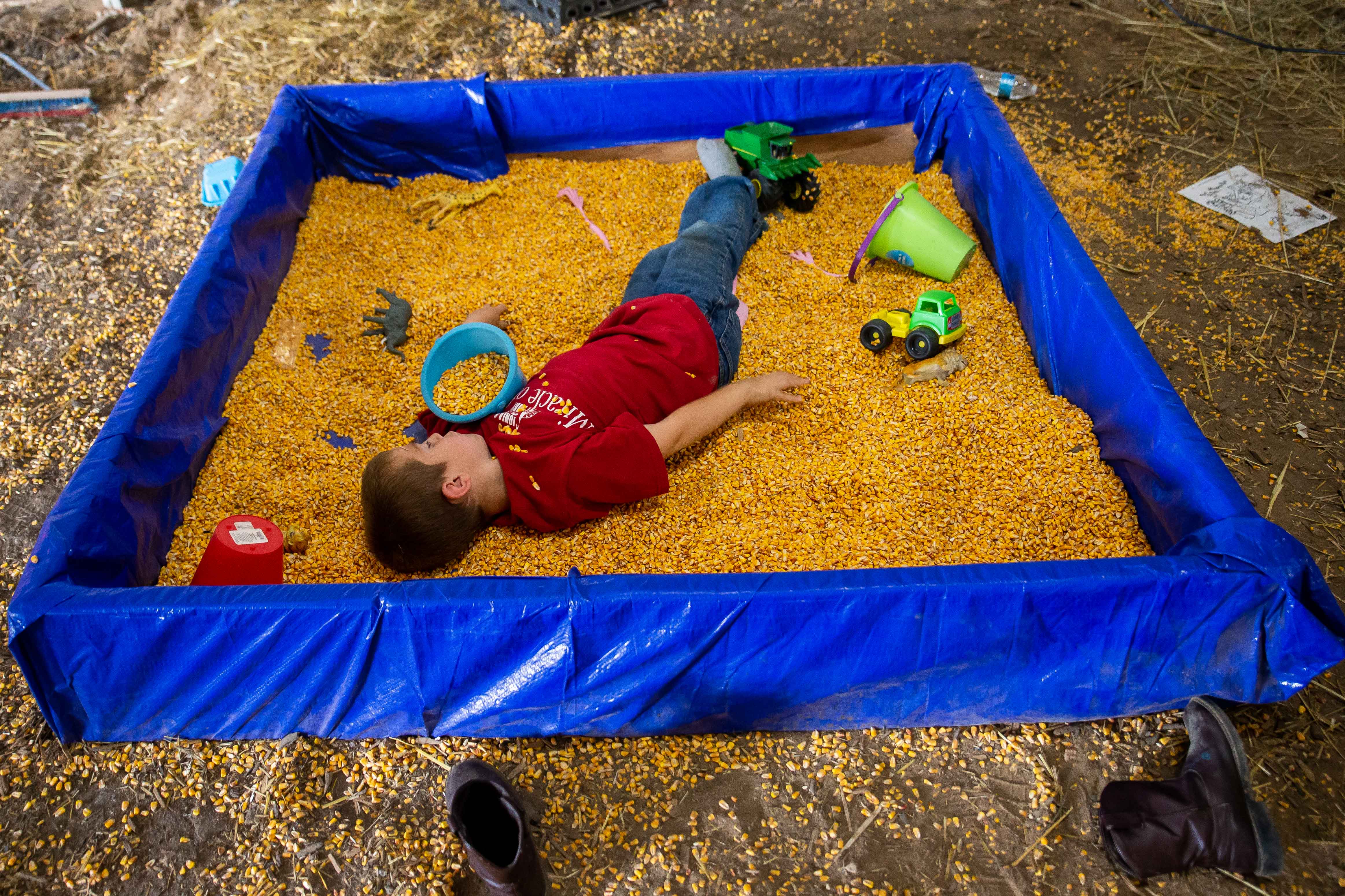 A young fair-goer takes a rest from the warm weather in the corn play place Tuesday, July 19, 2022, at the Ionia Free Fair. 