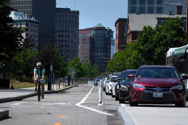 A cyclist pedals along the bike lane on South Water Street. Business owners in the area say the bike path and other changes the city has made on that street have eliminated dozens of parking spaces.