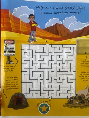 Children are given a puzzle to learn about uranium safety in their community.