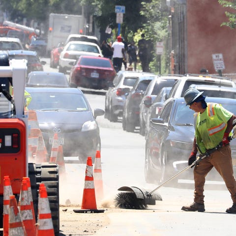 A City of Yonkers worker clears dirt from a roadwo