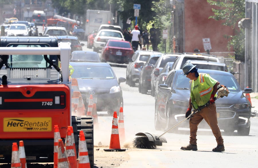 A City of Yonkers worker clears dirt from a roadwork project in Yonkers, N.Y. during a sweltering afternoon July 20, 2022. The current heatwave will keep temperatures in the New York City region in the 90's through this coming weekend.
