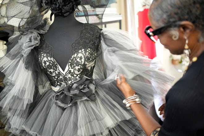 Joan Madison, the designer behind Joan's Bridal Couture, examines the sleeves of a custom gown she created inside her Reynoldsburg store and workspace on July 21, 2022. Adam Cairns-The Columbus Dispatch