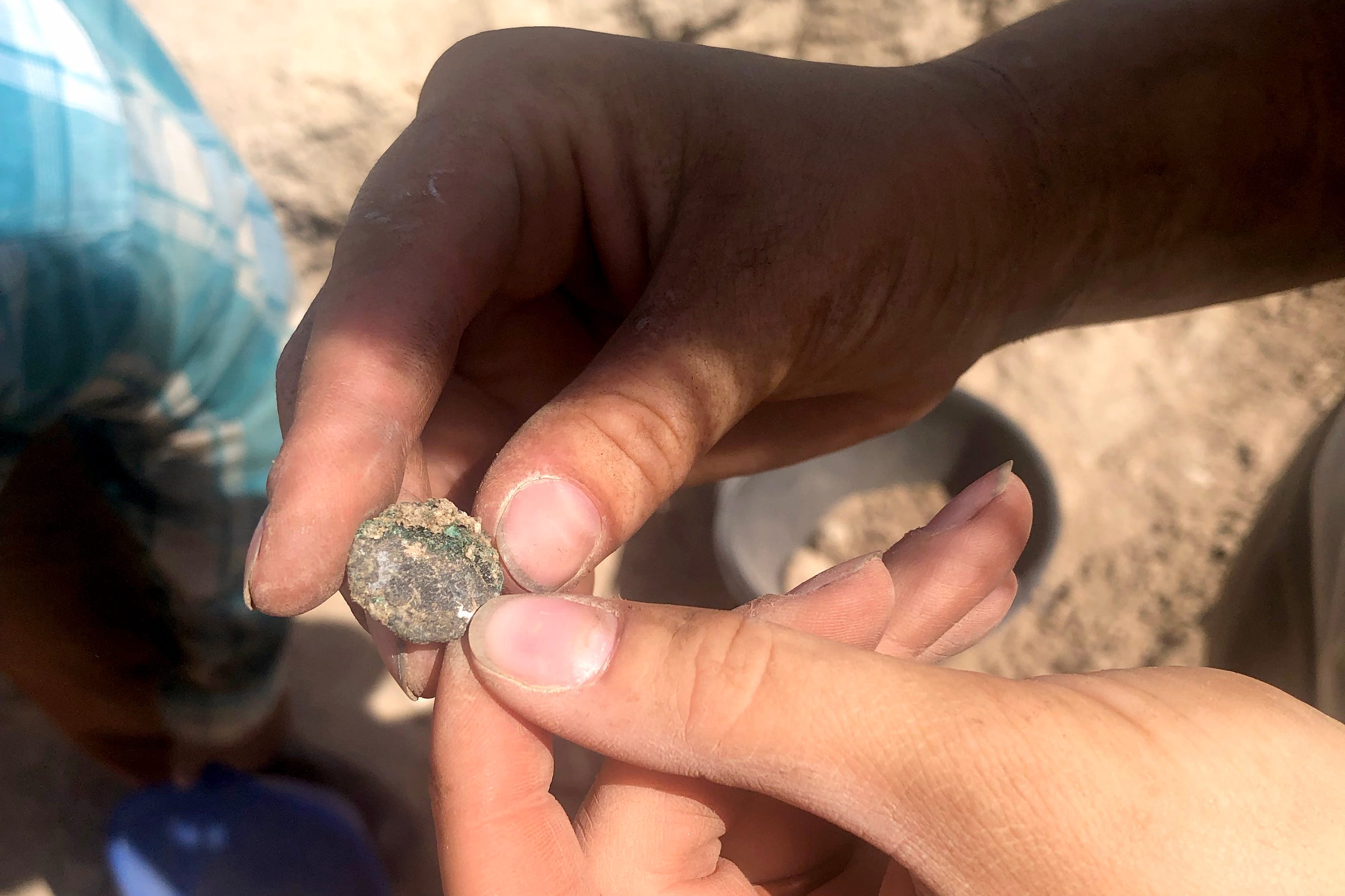 UC student Lizzy Hallett holds an ancient coin the team uncovered in Trench 5000 in mid-June.