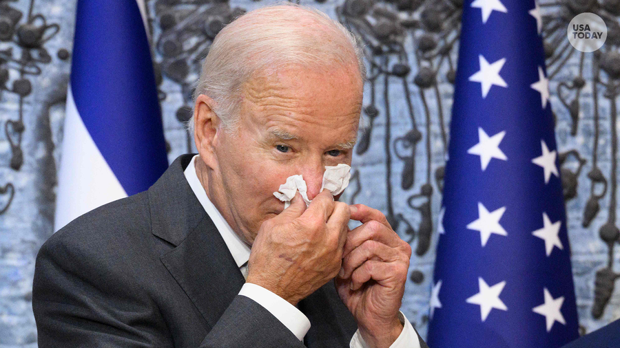 In this file photo taken on July 14, 2022, US President Joe Biden wipes his nose after signing the guest book while visiting Israel's President Isaac Herzog at Beit HaNassi, the presidential residence in Jerusalem. - Biden said on July 21, 2022, he was "doing great" after the White House announced he had contracted Covid-19 and was isolating with mild symptoms. "Folks, I'm doing great," Biden tweeted, above a picture showing him seated at his desk, smiling, with smartphones and   documents laid out in front of him. "Thanks for your concern," the president wrote, adding: "Keeping busy!" (Photo by MANDEL NGAN / AFP) (Photo by MANDEL NGAN/AFP via Getty Images)