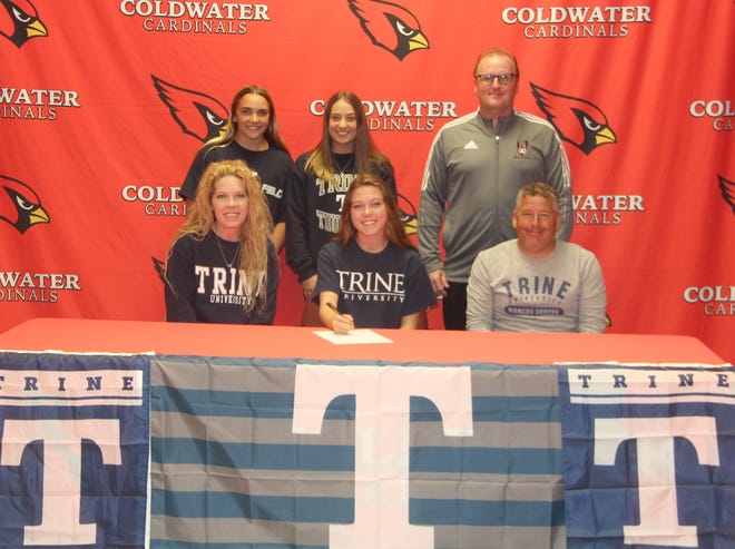Coldwater's Masyn Marsh (center), surrounded by family, friends an coaches, signs her letter of intent to attend Trine University to play soccer.