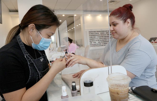 Molinda Mot gives a manicure to Michelle Paquette, of Chelmsford, at Coco Nail Bar in Westford, July 22, 2022.