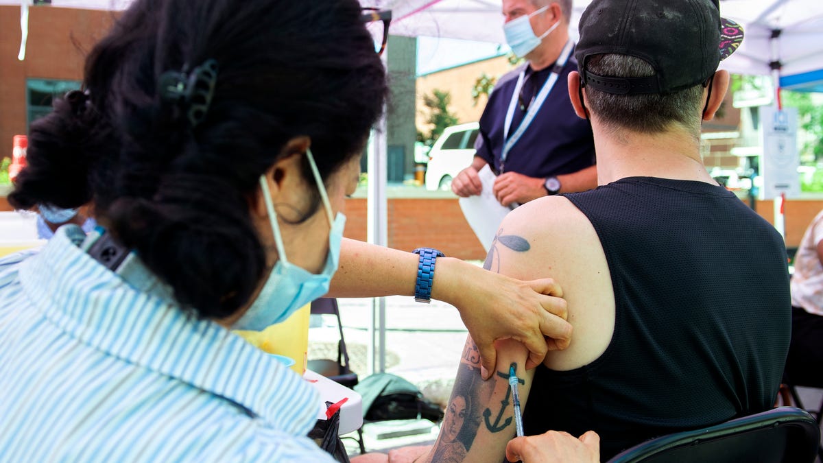 Brian Maci, from New York, receives a monkeypox vaccine at an outdoor walk-in clinic in Montreal, Saturday, July 23, 2022. Tourists are among those lining up to get monkeypox vaccines in Montreal, as the World Health Organization declares the virus a global health emergency.