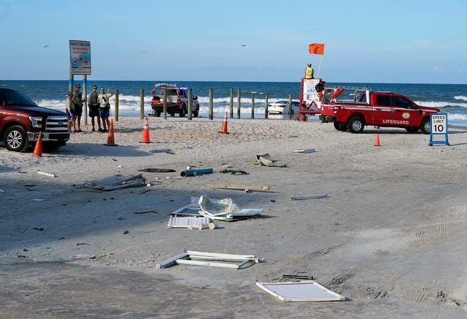 Debris from a toll booth destroyed by an out-of-control car is strewn along the beach approach to International Speedway Boulevard in Daytona Beach on Sunday.