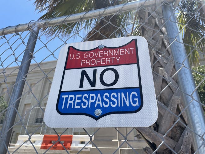 A no trespassing sign hangs on a construction fence outside the Alton Lennon Federal Building and U.S. Courthouse on July 25, 2022. The building has been closed for repairs since Hurricane Florence in 2018.