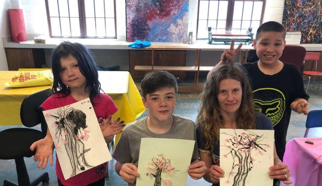 Family Promise of Greater Des Moines offers weekend art activities for its guests. A member of Westminster Presbyterian Church and a former art instructor volunteers her time to gather guests twice a month for art activities using various mediums. The first art session was April 6 with the theme of "Chinese art." Pictured with their art: Baylee, Thomas, Mary and Julian.