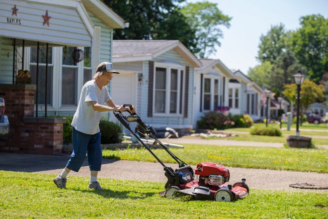 Joyce Bayles, 85, mows the lawn around her home in the Ridgeview Homes mobile home community in Lockport, N.Y. , June 23, 2022. The 85-year-old resident has taken to mowing her own lawn because crews for Ridgeview show up only monthly. Bayles is not participating in a rent strike with other residents of Ridgeview and doesn't want to get involved. "They're going to raise the rent and there's nothing I can do about it," said Bayles.