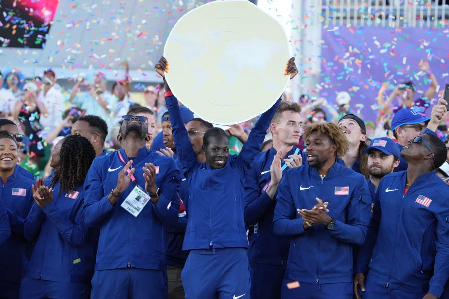 July 24: The United States track and field team, with Athing Mu holding the championship trophy, celebrates as team champions at the World Athletics Championships Oregon 22 at Hayward Field. Team USA won 33 medals (13 gold) at the world track and field championships. The most ever by any nation.