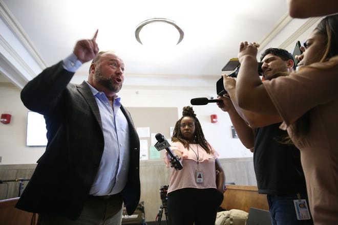 Alex Jones talks to media during a midday break during the trail at the Travis County Courthouse Tuesday, July 26, 2022. Jones has been found to have defamed the parents of a Sandy Hook student for calling the attack a hoax.