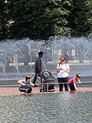 The kids are having a good time exploring the reflecting pool at the Christian Science Center.