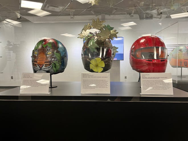Three of nine helmets created by local artists on display at Sleek: The Art of the Helmet, the new exhibition at the Indianapolis Motor Speedway. From left to right, they were created by Greg Potter, Nancy Lee and April Knauber.