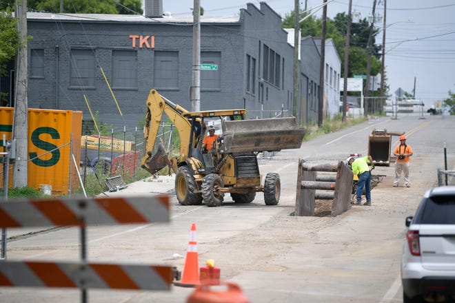 Workers dig a hole on Jackson Avenue as work begins at the Old City multiuse stadium construction site in Knoxville, Tenn. on Tuesday, July 26, 2022.