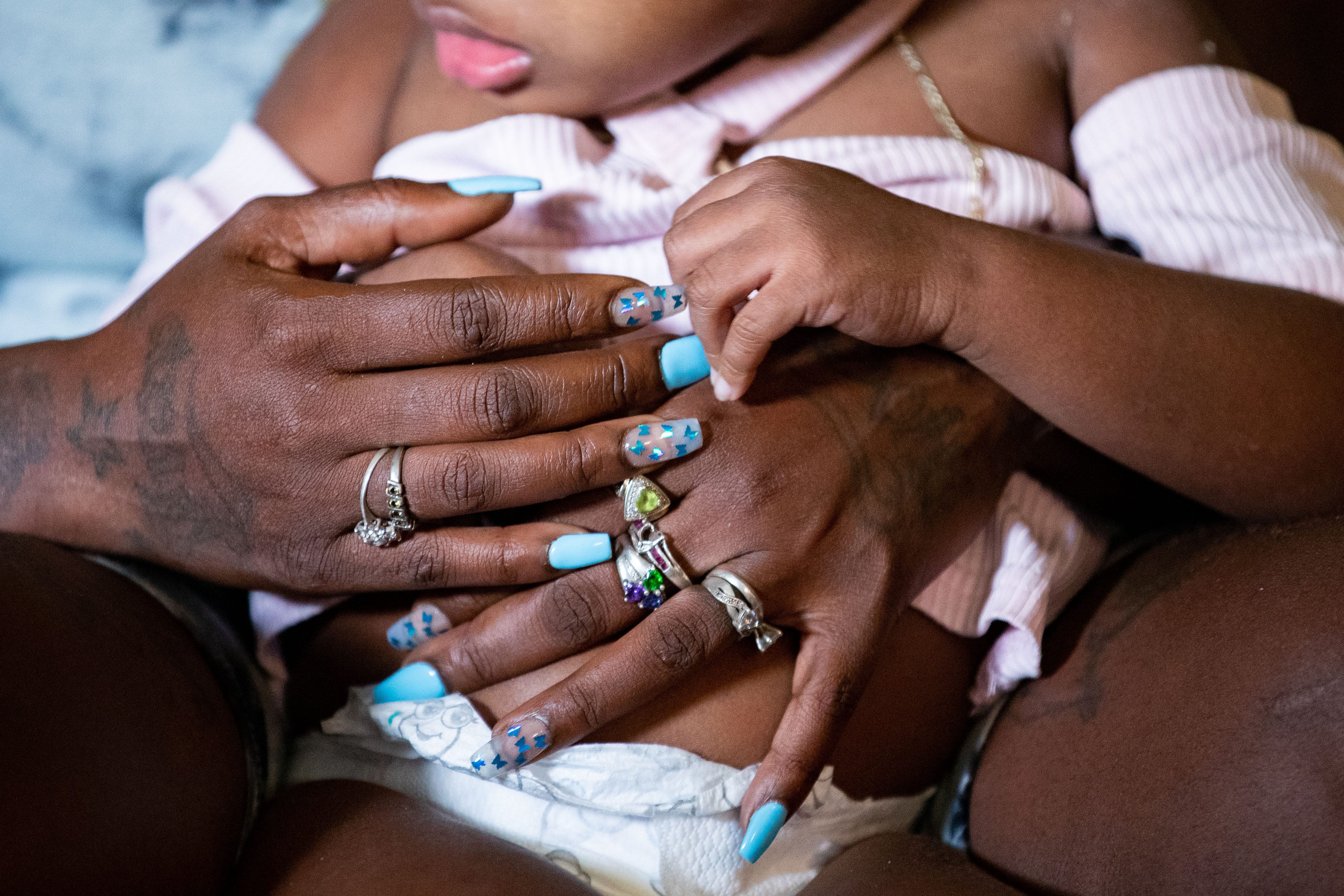 Chrisstine 'Chrissy' Daniels holds her daughter, TeSharria, 5, as she recalls the struggles she had during her pregnancy Wednesday, July 6, 2022.