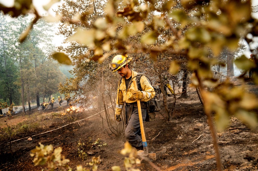 Firefighter Sergio Porras mops up hot spots while battling the Oak Fire in the Jerseydale community of Mariposa County, Calif., on Monday, July 25, 2022. He is part of Task Force Rattlesnake, a program comprised of Cal Fire and California National Guard firefighters.