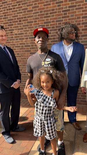 Quinton Burns and daughter, Kennedi, 5, of Baltimore, stand outside federal court in Philadelphia after their attorneys filed a federal lawsuit on their behalf against Sesame Place.